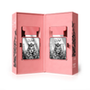 A professional product display showing two Qamarain For Her perfume bottles nested inside an elegant, pink-themed presentation box, decorated with artistic portrait illustrations.